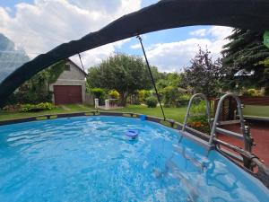 a swimming pool with a swing in a backyard at Agroturystyka oTuLisko - Piękny Ogród, Basen, Cisza, Zwiedzanie Atrakcji, Blisko Bałtów in Kunów
