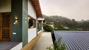 a house with a balcony with a view of a mountain at LiveAway Mukteshwar, Nainital by PACK in Mukteswar