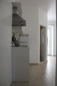 una cucina con pareti bianche e piano cottura forno superiore di Apartment Iva a Spalato (Split)