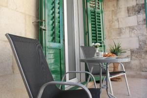 una mesa y sillas en un patio con ventana en Apartment Iva en Split