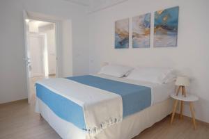 a white bedroom with a blue and white bed at B&B Antica Dimora in Petacciato