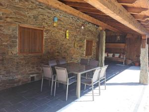 a wooden table and chairs on a patio at Casa Dos Avós - Alojamento Local in Bragança