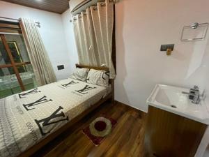 Un dormitorio pequeño con una cama y un lavabo. en Zion Apostolate, en Athirappilly