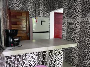 a kitchen with a counter and a refrigerator at Casa na mata in Ilhabela