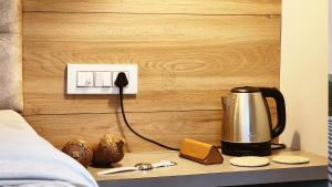 a tea kettle on a table next to a bed at LiveAway Mukteshwar, Nainital by PACK in Mukteswar