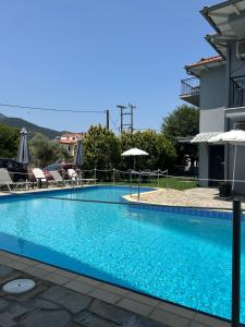 a large blue swimming pool next to a building at Aliston Hotel Thassos in Skala Potamias