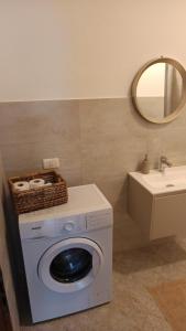 a washing machine in a bathroom with a sink at Appartamento Bianco - Peschiera del Garda in Peschiera del Garda