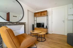 a living room with a chair and a mirror at Studio Cosy à Fontainebleau in Fontainebleau