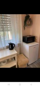 una pequeña cocina con microondas y mesa en Nuoma centre, en Palanga