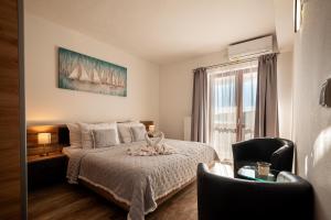 a bedroom with a bed and a chair and a window at Black Pearl Tisno in Tisno