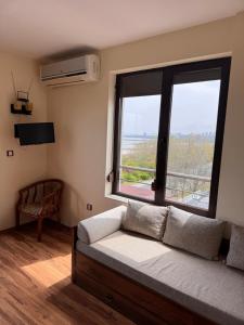 a room with a couch and a large window at Sea View Escape in Burgas