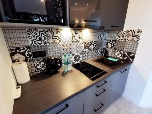 a kitchen with black and white tiles on the wall at Domki Bliżej Gwiazd in Krasnobród