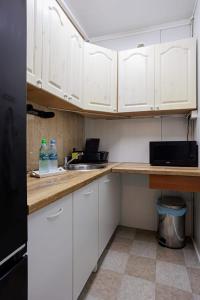 a small kitchen with white cabinets and a sink at Domki Bliżej Gwiazd in Krasnobród +8 photos
