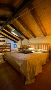 a large bed in a room with wooden ceilings at Casa Felicina in Rubiana