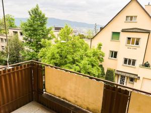 einen Balkon mit einem Holzzaun und Gebäuden in der Unterkunft City Center Flats with Balcony & Garden View Rigi - Self Checkin in Zürich