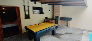 a ping pong table in a room with a fireplace at Mais Motel e Hotel in Lucélia