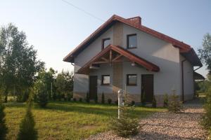a house with a red roof at Apartamenty Jaśmin i Lilia jez. Sunowo koło Ełku in Chrzanowo