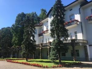 a large white building with trees in front of it at Apartman Harmony 5 in Banja Koviljača