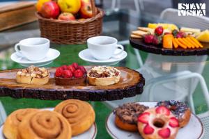 a table topped with plates of pastries and fruit at StayVista at Bael Leaf with Projector Setup, Pool in Nashik