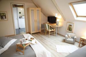 a attic room with a bed and a table and a desk at Chambres d'Hotes Losten ar Gogues in Trédarzec