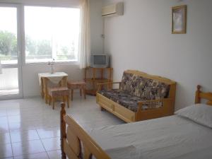 a bedroom with a bed and a couch and a table at Guest house Horizont in Balchik