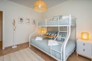 a bedroom with a bunk bed with a desk at Bright Flat w/ Terrace & Pools by HostWise in Tavira +16 photos