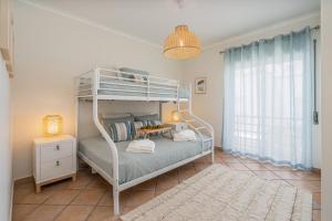 a bedroom with a bunk bed with a lamp and a rug at Bright Flat w/ Terrace & Pools by HostWise in Tavira