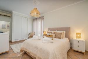 a bedroom with a large bed with two pillows on it at Bright Flat w/ Terrace & Pools by HostWise in Tavira