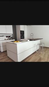 a kitchen with white cabinets and a sink and a counter at Domu sa luna mia in Villasimius