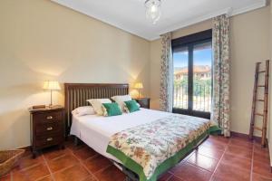 a bedroom with a bed and a large window at Casa Gredos- Chimenea , Setas , BBQ , Relax in Mombeltrán