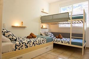 ein Schlafzimmer mit zwei Etagenbetten und einem Fenster in der Unterkunft Apartamento,BBQ, cerca del mar in Charco del Pino