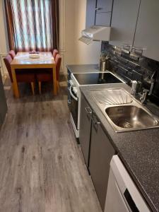 cocina con fregadero y mesa en Ben's cozy home close to the river and city, en Rovaniemi