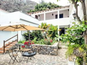 a patio with a table and an umbrella at Casa la plaza in Agulo