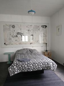 a bedroom with a bed and a wall with drawings at Art House & Sculpture Garden in Mänttä