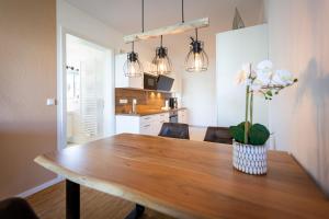 Una mesa de comedor con un jarrón de flores encima. en Quartier 7 App 05, en Ahlbeck 18 fotos más
