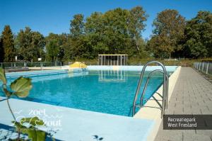 a large swimming pool with blue water at Holiday-Home HELMGRAS 5p. Amsterdam and the beach in Opmeer