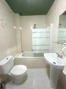 a bathroom with a toilet and a sink and a tub at Coronel Somiedo by Unusual Hotels in El Puerto de Somiedo +20 photos