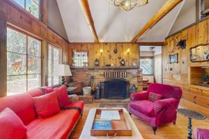 a living room with a red couch and a fireplace at Wildwood Cottage in Idyllwild