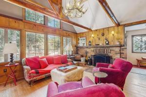 a living room with red furniture and a fireplace at Wildwood Cottage in Idyllwild