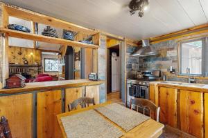 a kitchen with wooden cabinets and a table and a sink at Wildwood Cottage in Idyllwild +17 photos