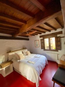 un grande letto bianco in una camera con soffitti in legno di Lanzaroco, tu casa en La Vera a Valverde de la Vera