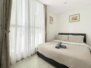 ein Schlafzimmer mit einem Bett und einem großen Fenster in der Unterkunft 7Teenhomes - SA CozyStay in Kota Kinabalu