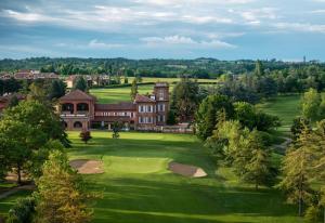 uma vista aérea de uma mansão com um campo de golfe em Country House Pais - Relax in jacuzzi tra i vigneti em Quargnento