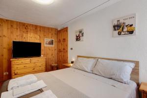 una camera da letto con un letto e una TV a schermo piatto di Ma Petite Maison ad Aosta