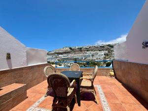 a patio with a table and chairs on a balcony at La Romana Apartment in Puerto Rico de Gran Canaria