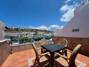 a patio with a table and chairs on a balcony at La Romana Apartment in Puerto Rico de Gran Canaria
