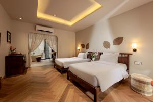 a hotel room with two beds and a couch at La Sen Village in Ninh Binh