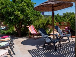 a group of chairs and an umbrella on a patio at Imperio de Memorias - Casa de Campo in Vale Bordalo