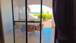 a dining room with a table and a view of the ocean at Romantic Chalete قرية الغرندل in Ras Sedr