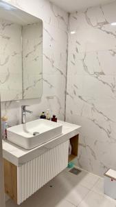a bathroom with a white sink and a mirror at Daik City Chaviland Fully Furnished Apartment in As Sulaymānīyah